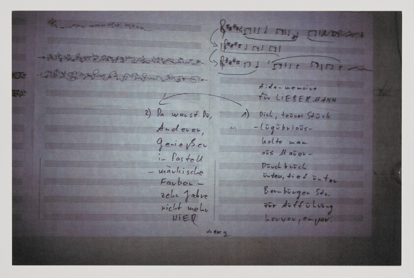 Handwritten musical score on staff paper with scribbled notes and German handwritten annotations.