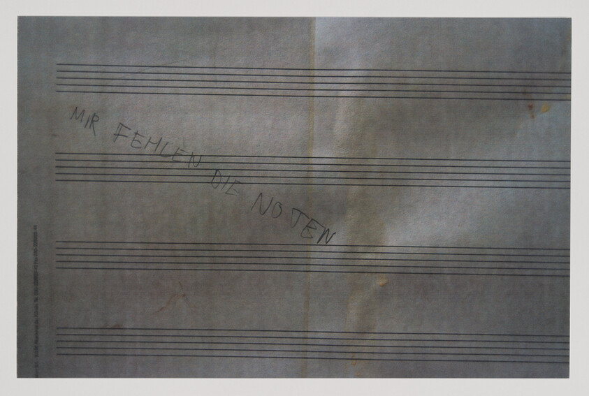 Blank sheet music paper with the handwritten German phrase "Mir fehlen die Noten" across the staves.