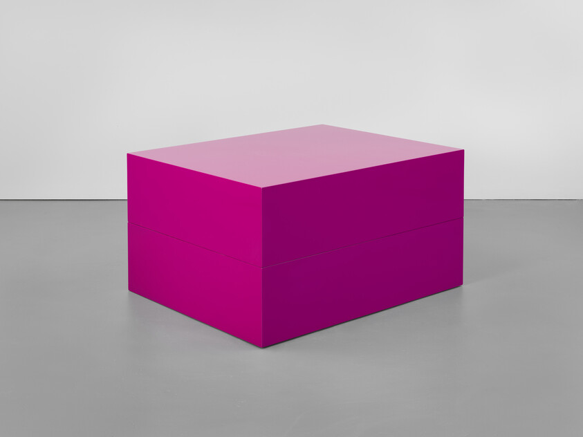 A large bright magenta rectangular box sits on a gray gallery floor.