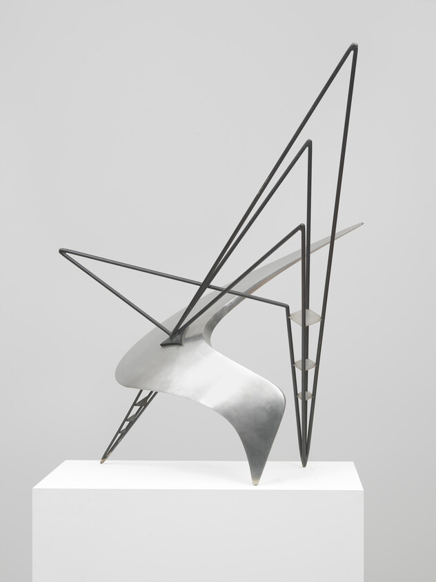 Abstract angular metal sculpture with sweeping curved sheet and triangular wireframe supports on a pedestal.