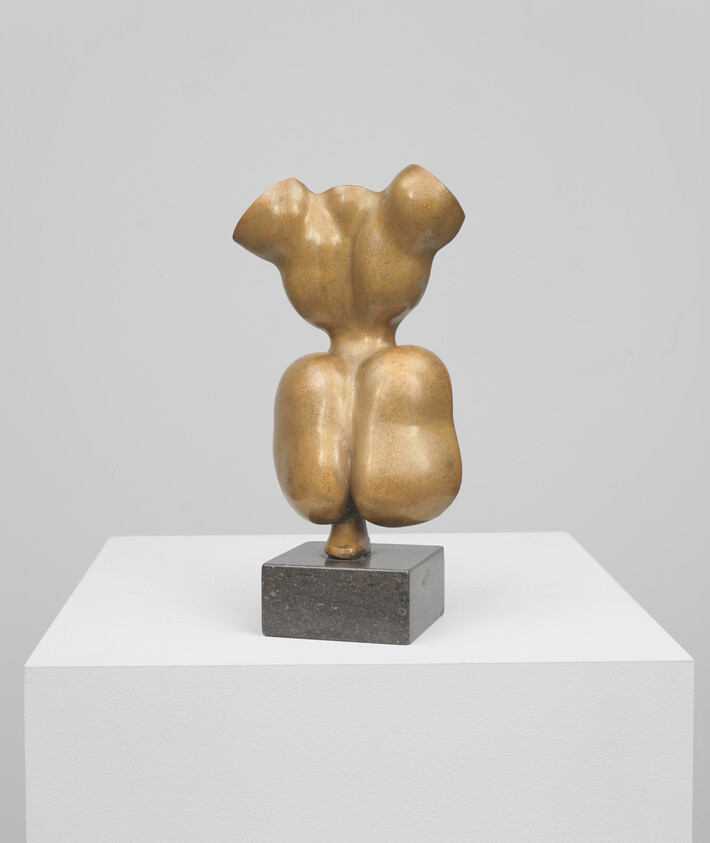 Small abstract bronze torso-like sculpture with rounded forms mounted on a square stone base.