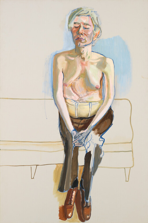 An older person sits on a couch wearing a post-surgical chest binder and clasping their hands.
