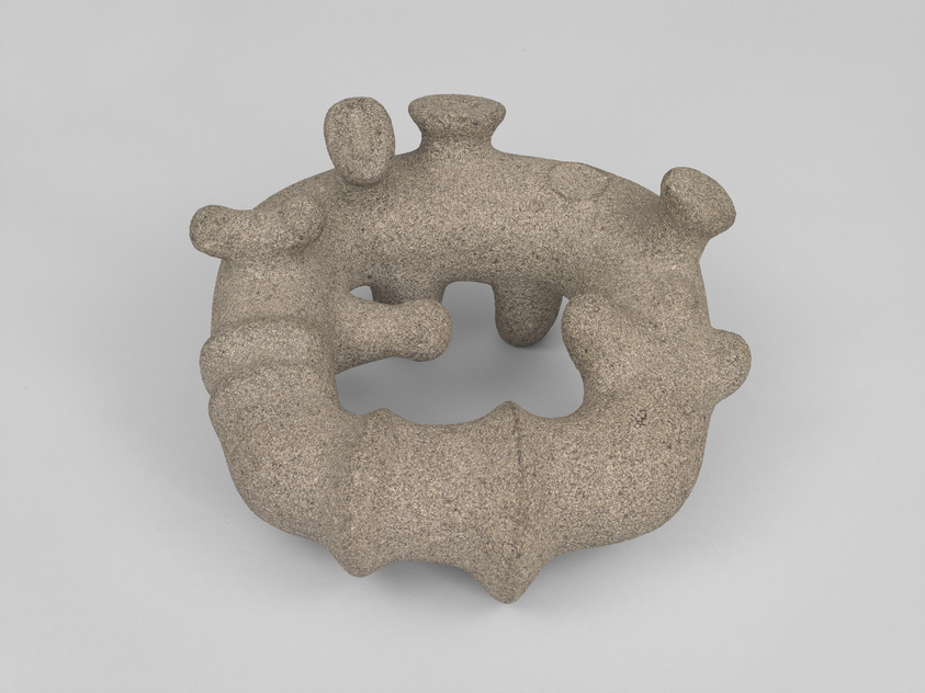 Doughnut-shaped sculpture with bulbous protrusions in unpolished granite