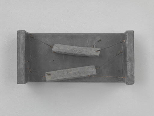 A shallow gray box with two suspended rectangular blocks hanging by thin wires inside.