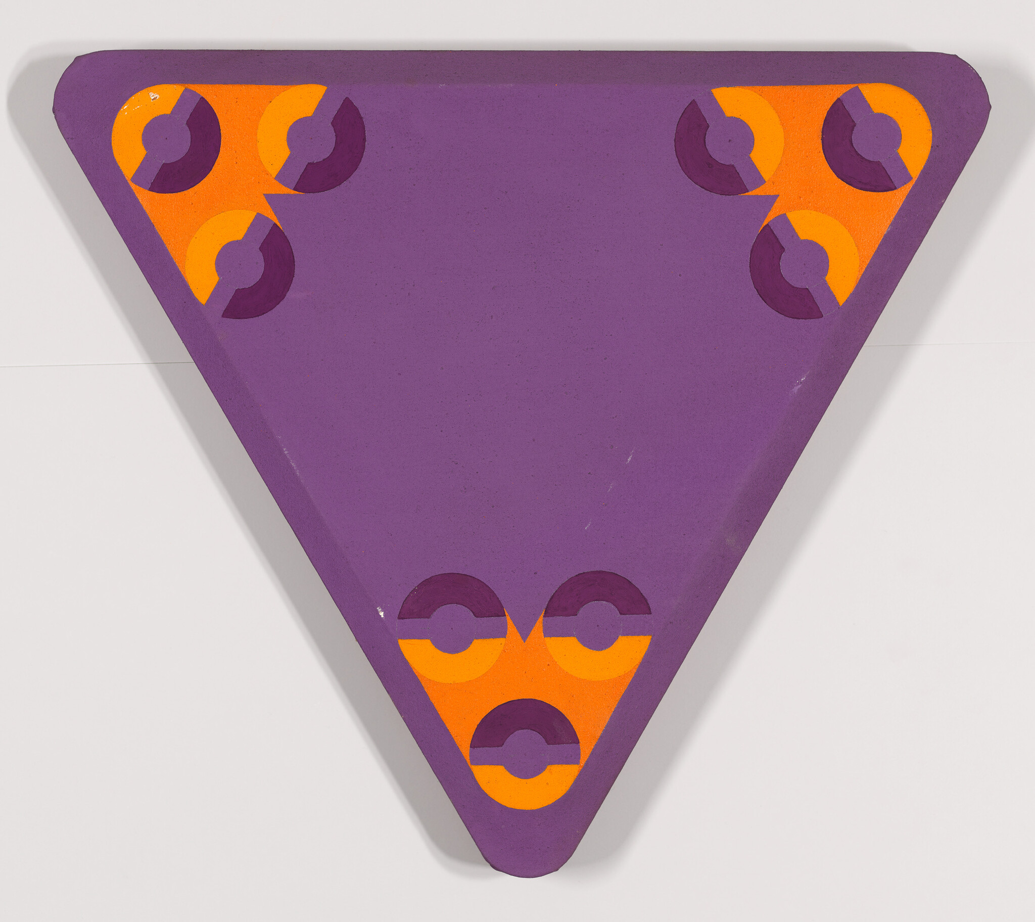A purple triangular board with orange corner panels featuring three circular purple-and-orange motifs.