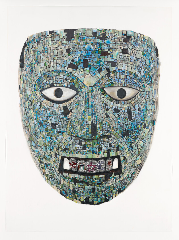 Large blue-green mosaic mask with wide eyes and detailed inlaid teeth mounted on a white background.