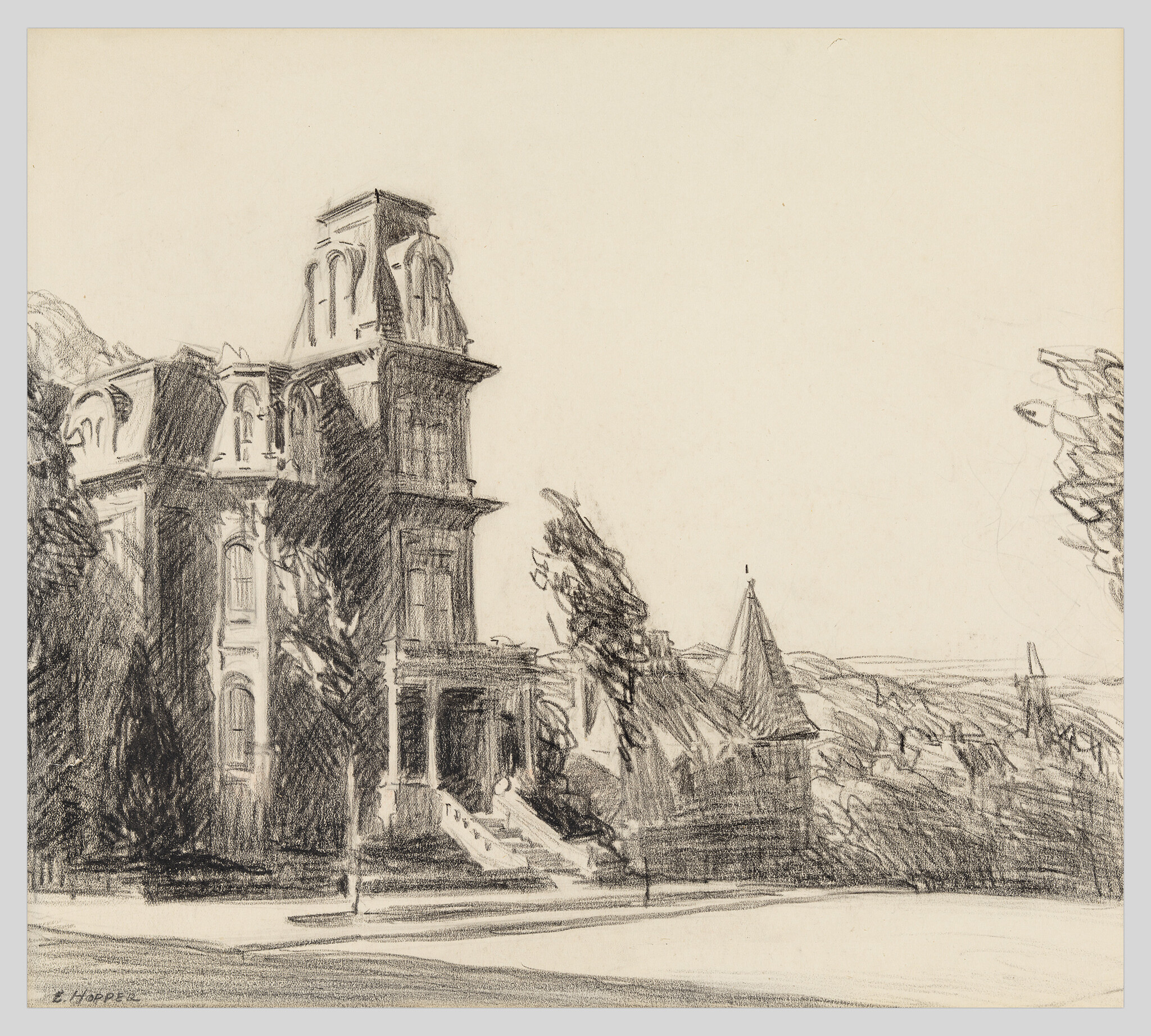 Large Victorian mansion with tower and front steps surrounded by trees on a quiet street.