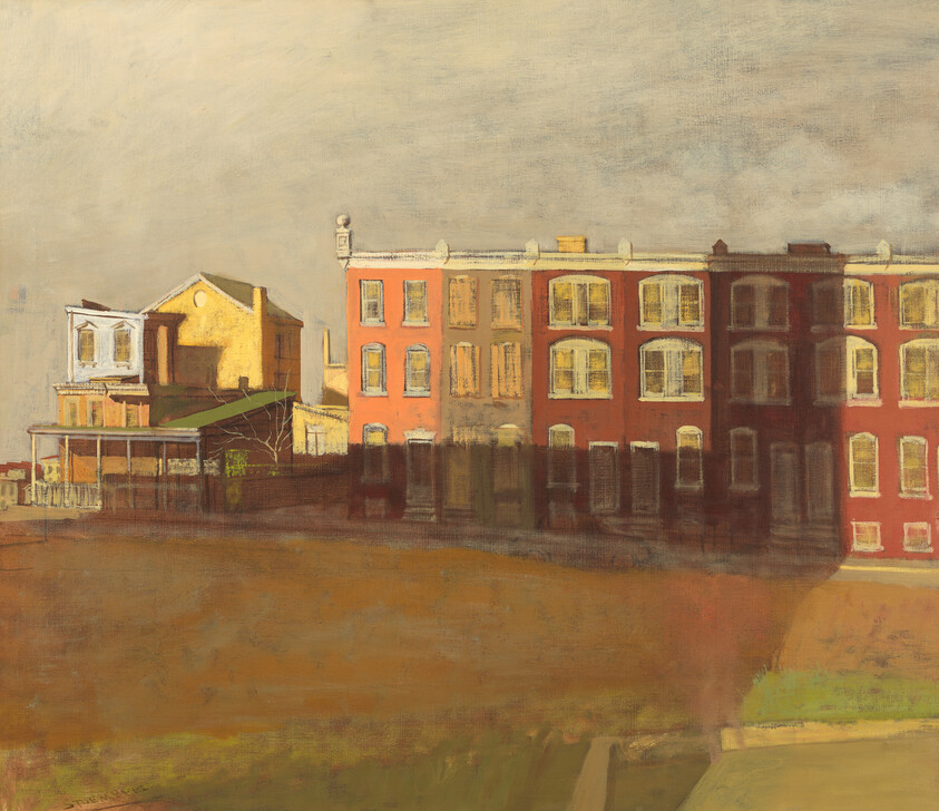 Sunlit row of red brick city buildings casting long shadows over a vacant brown lot.