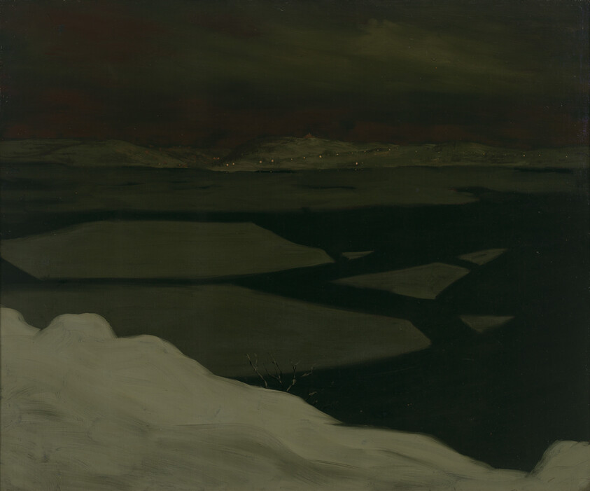 Snowy foreground overlooks dark frozen river with floating ice and small distant town lights.