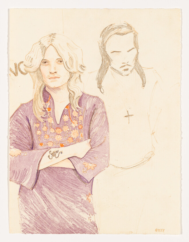 A person with long blond hair stands with arms crossed wearing a purple floral tunic and forearm tattoo.