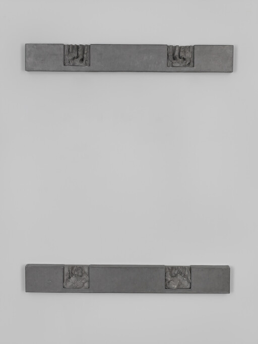 Two horizontal metal bars with small square reliefs mounted on a pale wall, top and bottom.
