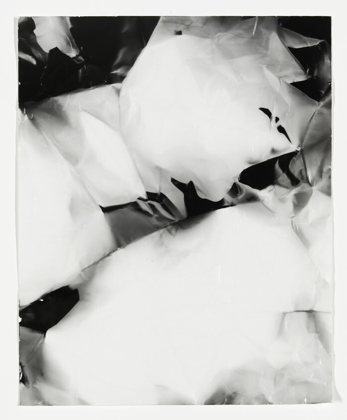 Crinkled metallic foil sheet with high-contrast light and dark reflections.