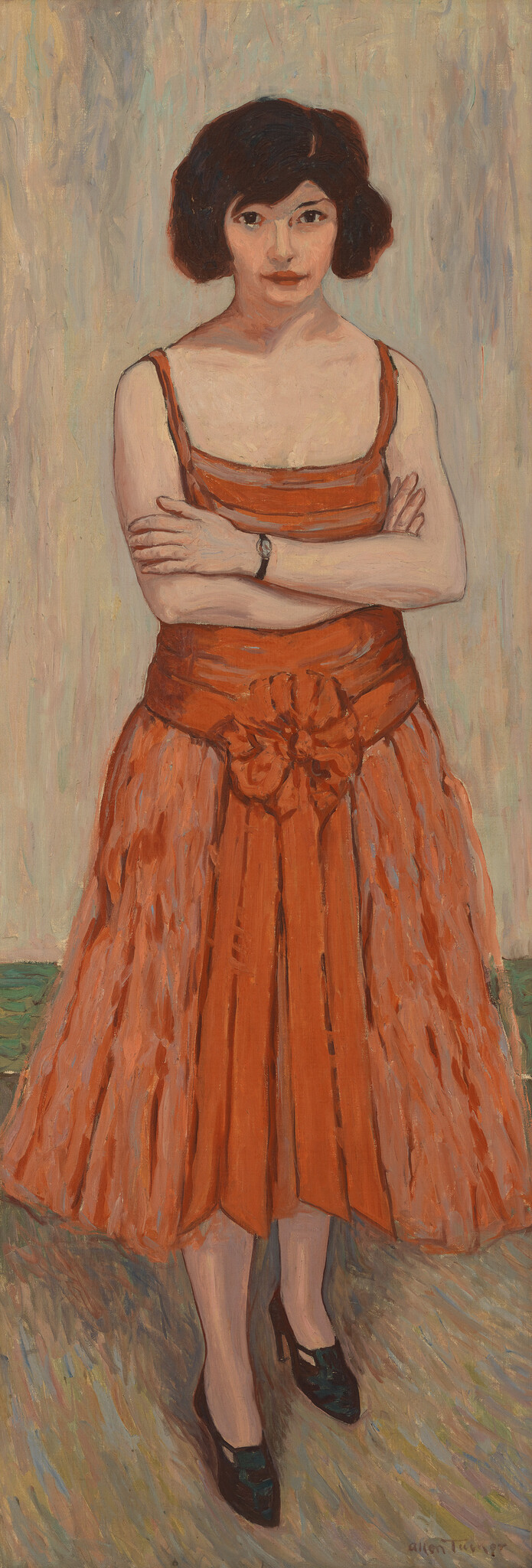 Young woman in an orange dress stands with arms crossed, looking directly at the viewer.