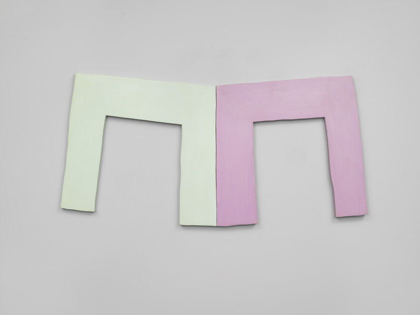 Two connected pastel green and pink rectangular frames mounted side by side on a gray wall.
