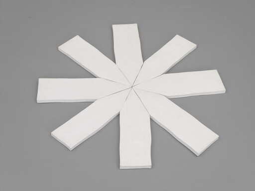 Eight white wooden planks arranged in a radial star pattern on a gray floor.