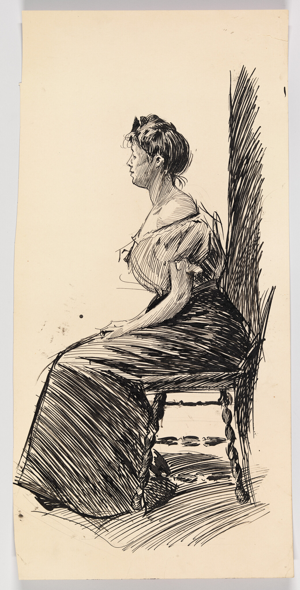 A woman in a long dress sits in profile on a wooden chair, hands resting in her lap.