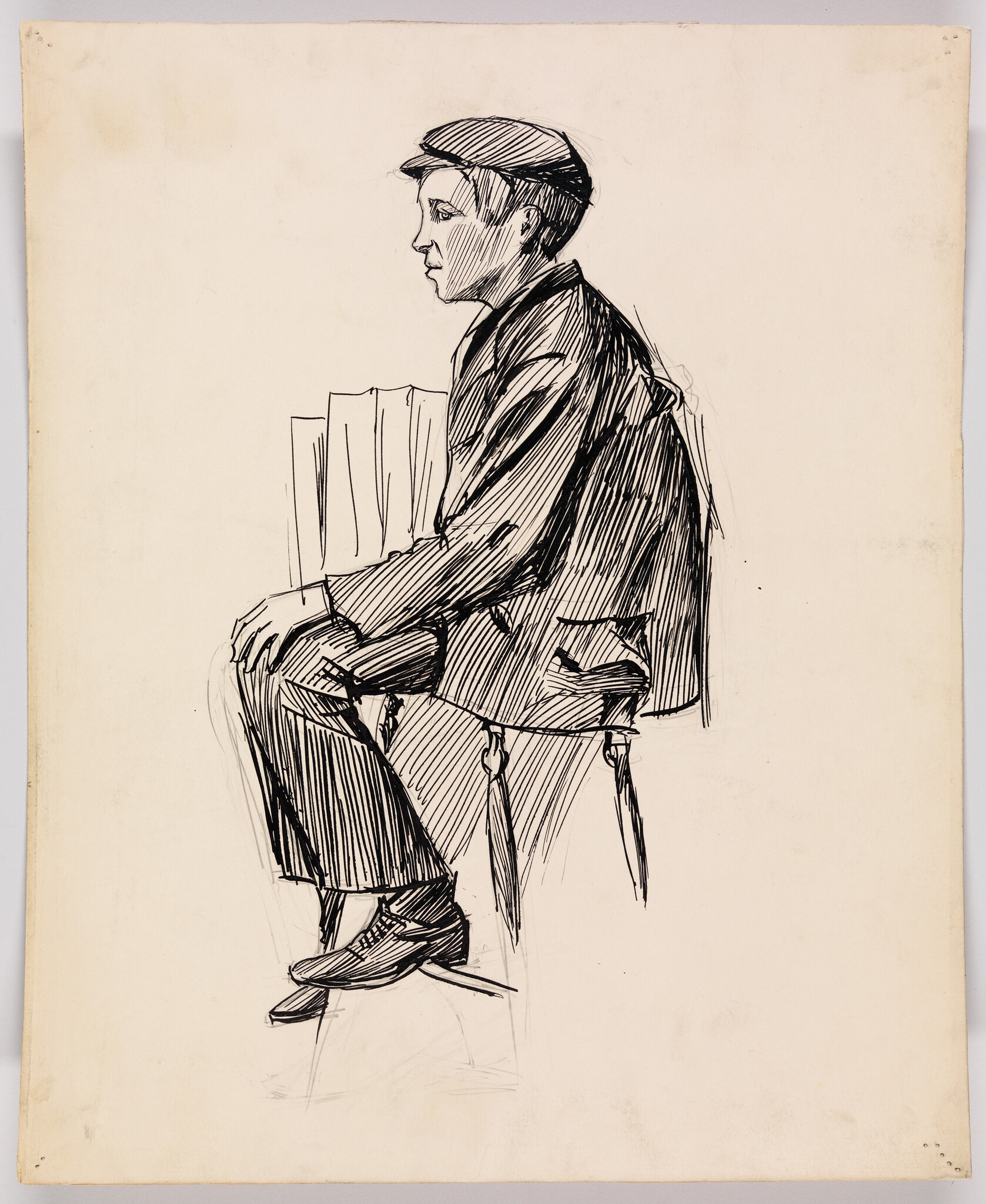 Young man in a cap sits on a stool with folded newspapers under his arm.