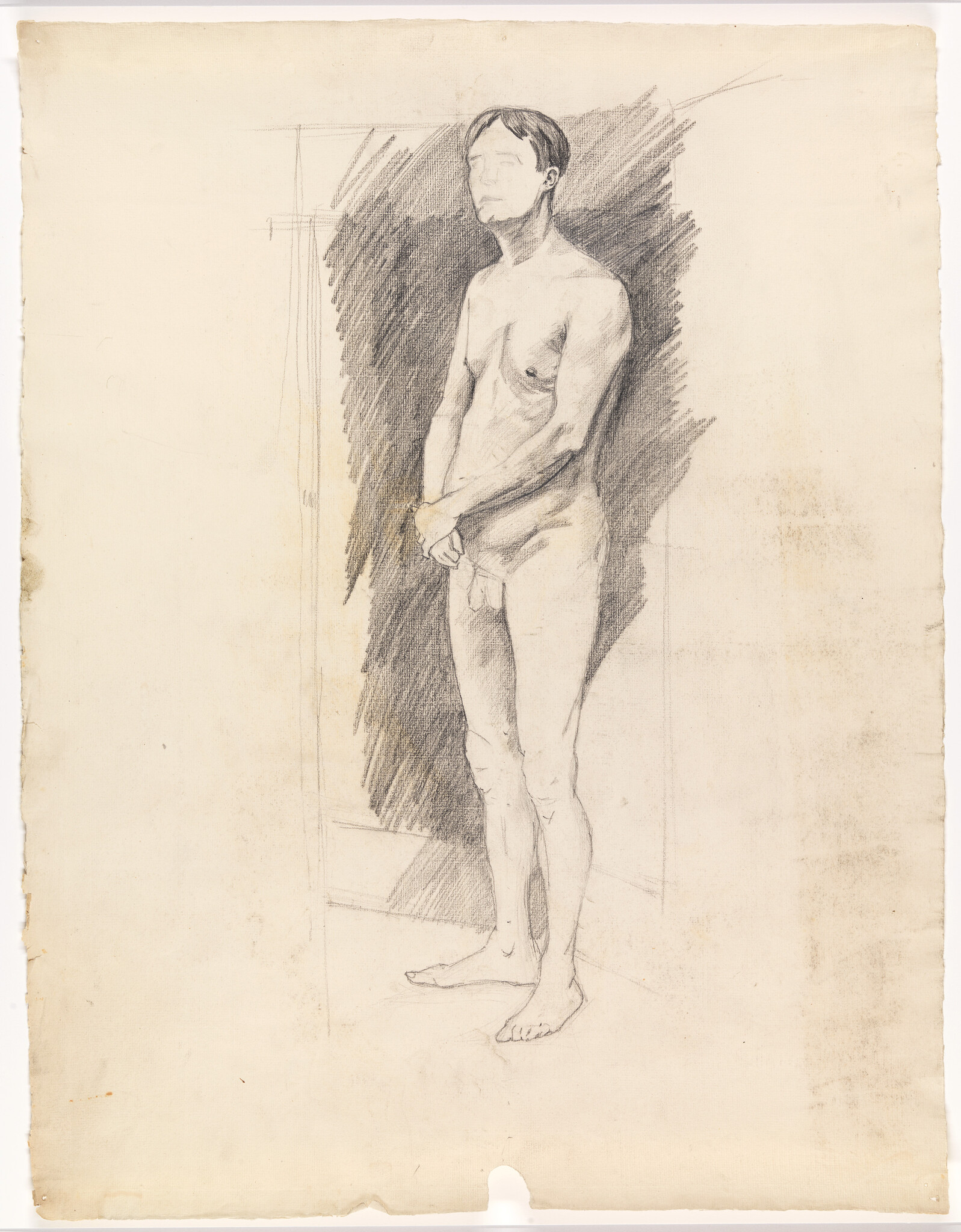 A standing nude male figure in pencil sketch with hands clasped covering his groin.
