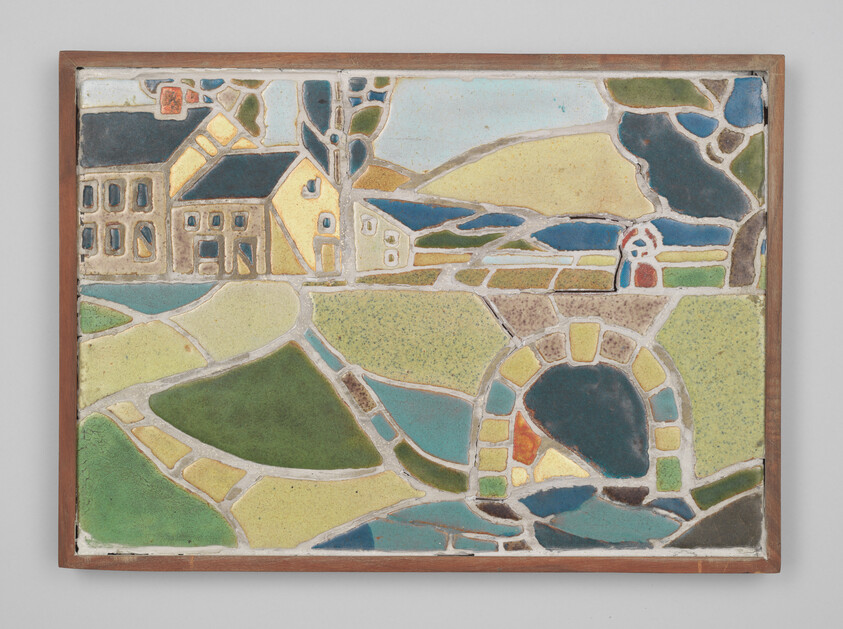A framed ceramic tile artwork depicting a stylized landscape with buildings, fields, and a circular water feature in a palette of muted colors. The scene is divided into geometric shapes, giving it an abstract, mosaic-like quality.