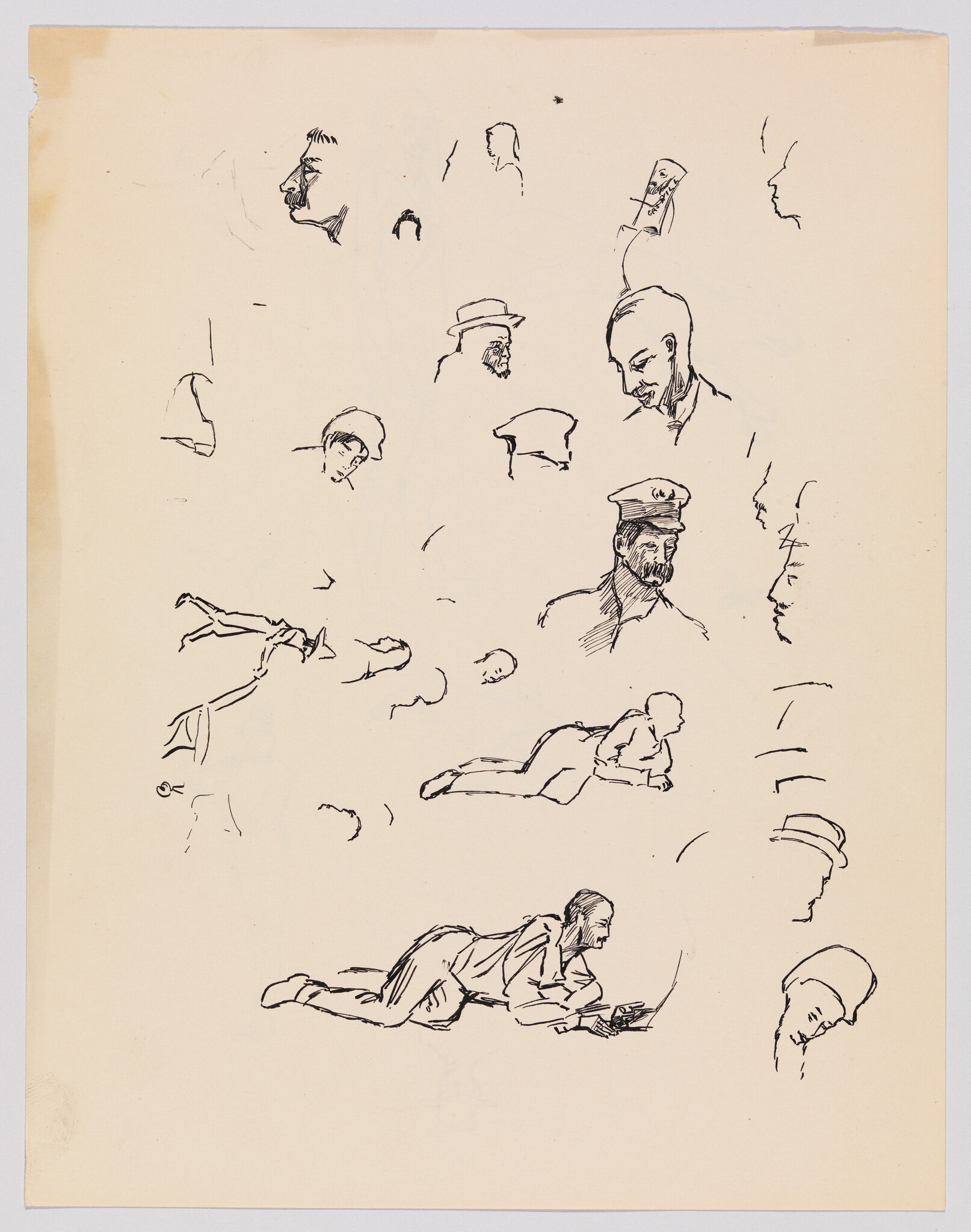 Various ink sketches of heads and a man lying on his stomach writing or drawing.