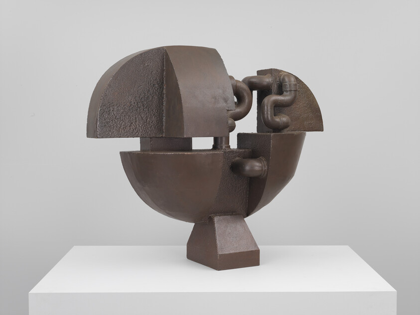 Brown metal spherical sculpture split into segments with curved pipe-like connectors on a pedestal.
