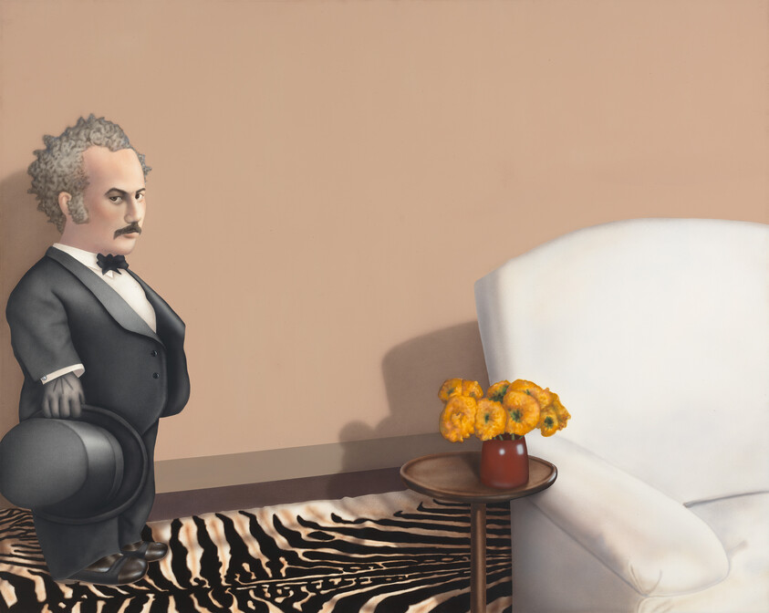 Short man in a tuxedo holding a top hat stands beside a zebra rug, table, and white armchair.