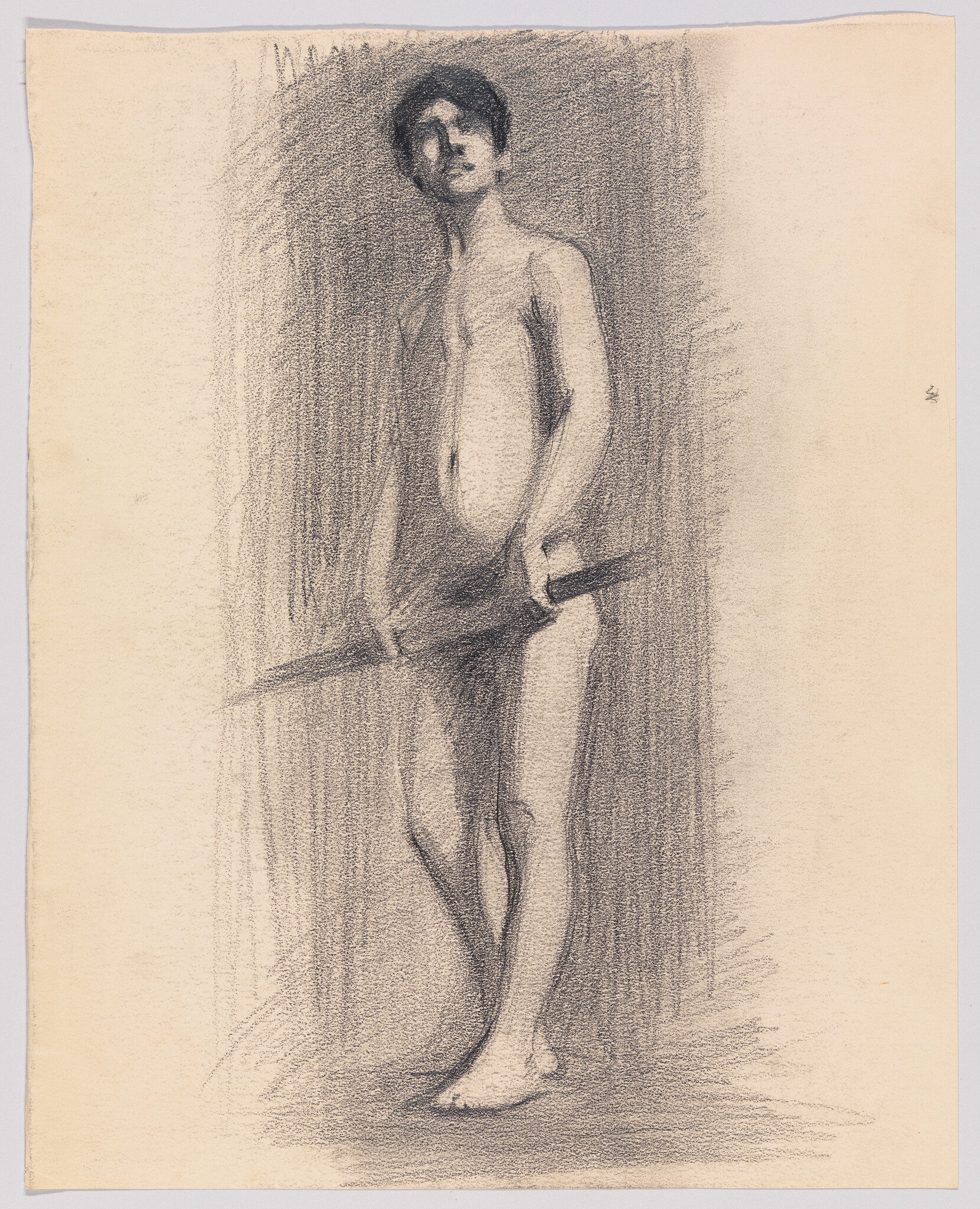 A standing nude young man holds a long stick across his hips, looking upward.
