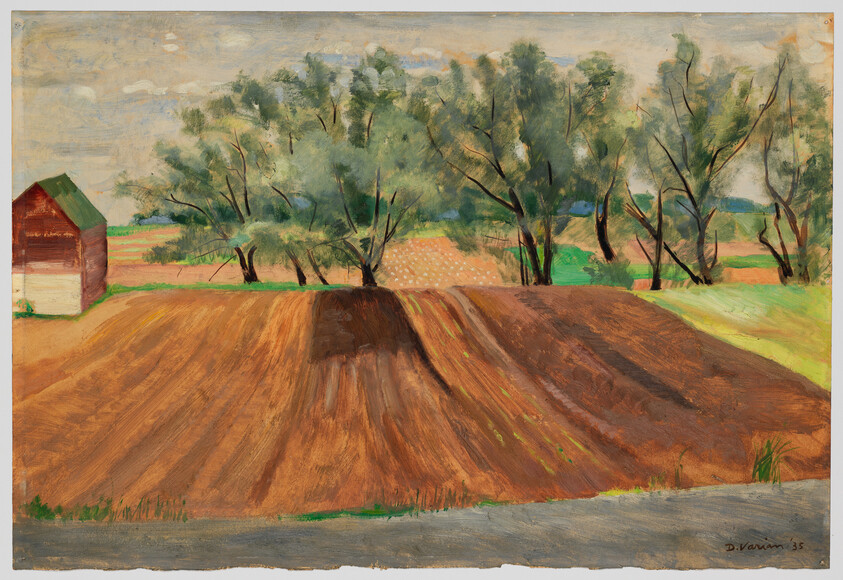 A freshly plowed field with a row of trees and a small red barn at left.