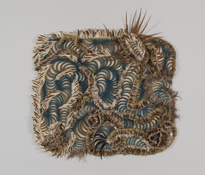 A square woven wall hanging with layered fringed fibers and swirling blue-green patterns.