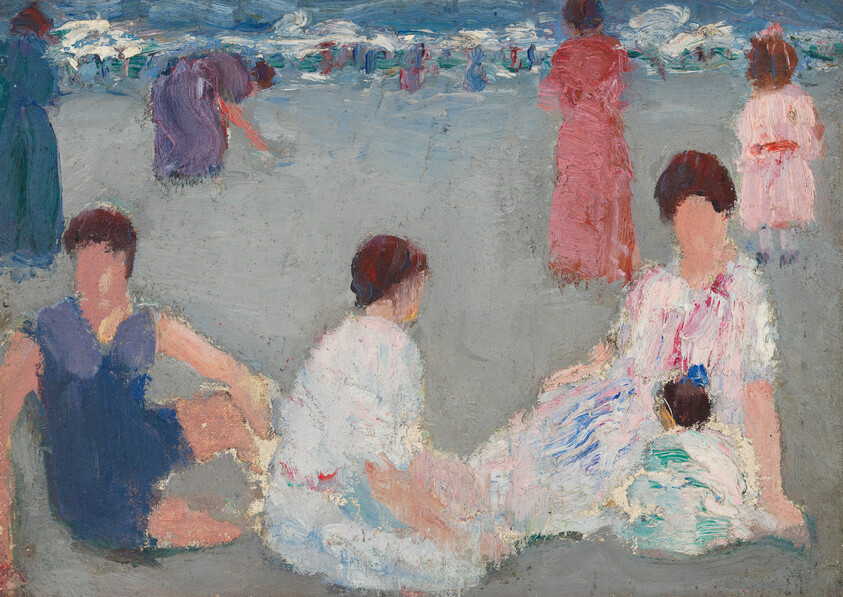 Women and children sitting and relaxing on a sandy beach with umbrellas in the distance.