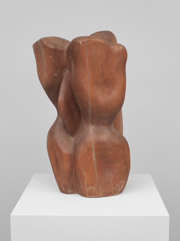 Abstract smooth brown wooden sculpture with rounded organic shapes displayed on a white pedestal.