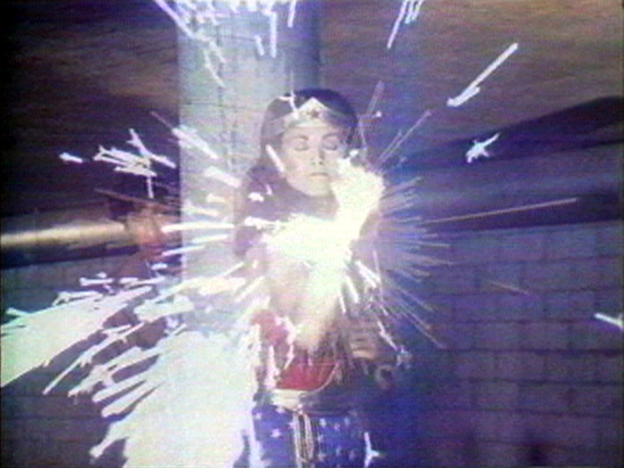 Wonder Woman stands with eyes closed as bright sparks burst from her hands.