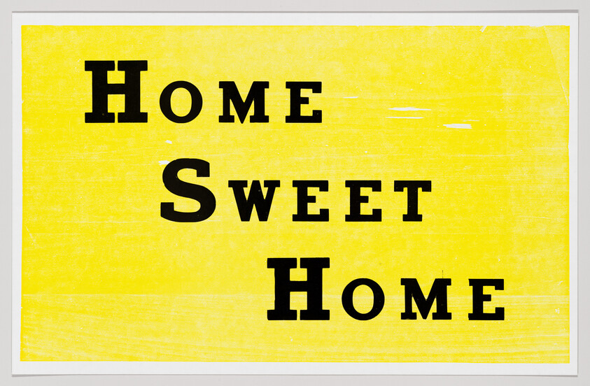 Yellow sign with bold black text reading "Home Sweet Home" in three stacked lines.