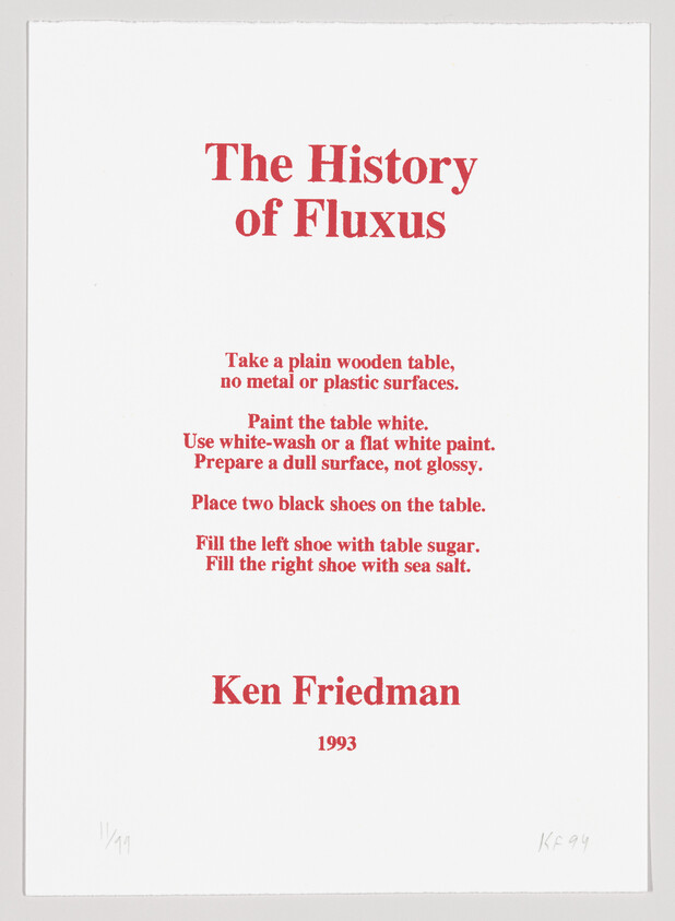 A printed artwork with red text on a white background titled "The History of Fluxus" by Ken Friedman, dated 1993. The text includes instructions involving a plain wooden table, painting it white, and placing two black shoes on it, one filled with table sugar and the other with sea salt. There is a signature and edition number at the bottom left corner.