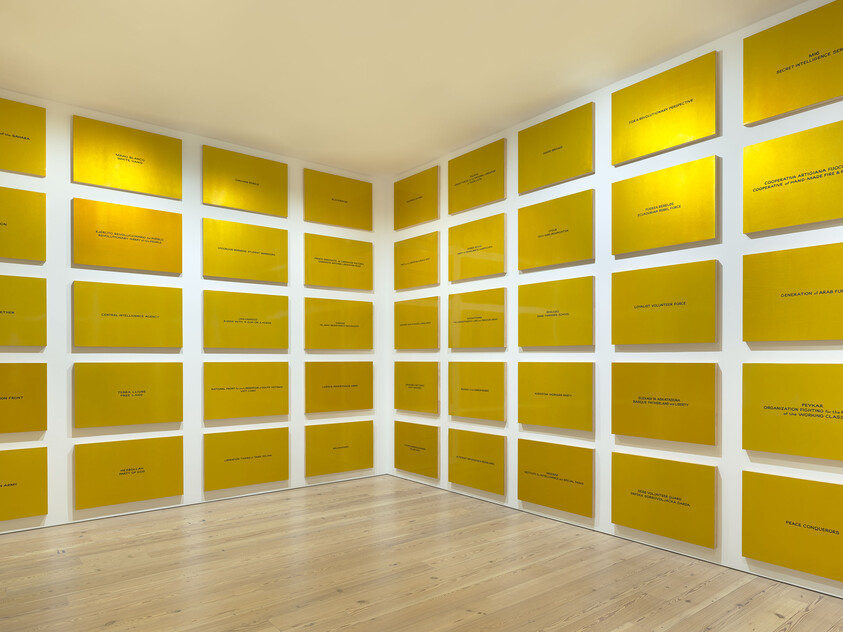 Walls covered with a grid of yellow rectangular panels, each featuring small centered text.