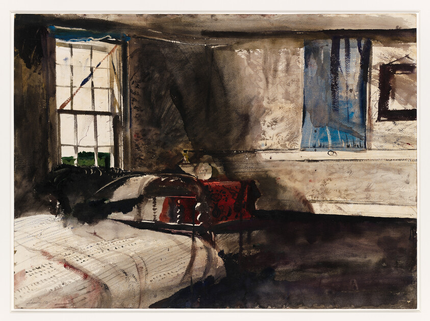 A dim bedroom with a bed by a window and a small table draped in red cloth.