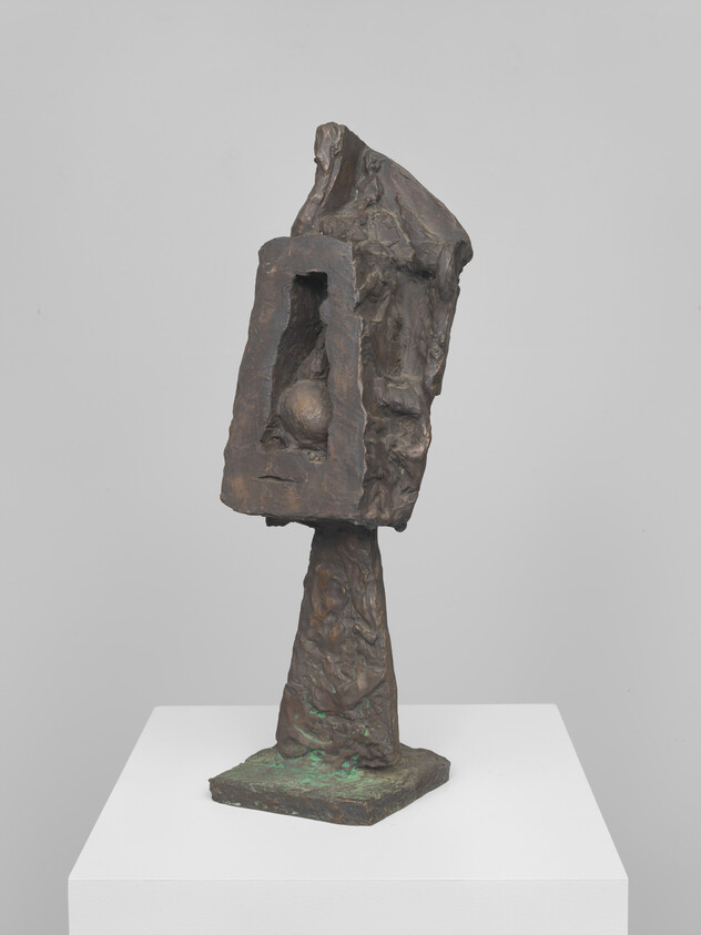 Bronze abstract sculpture on a pedestal featuring a hollow rectangular head with a sphere inside.