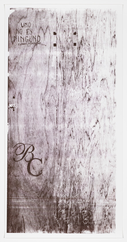 A wooden surface with graffiti, including the Spanish phrase “UNO NO ES NINGUNO” and large letters “BC.”