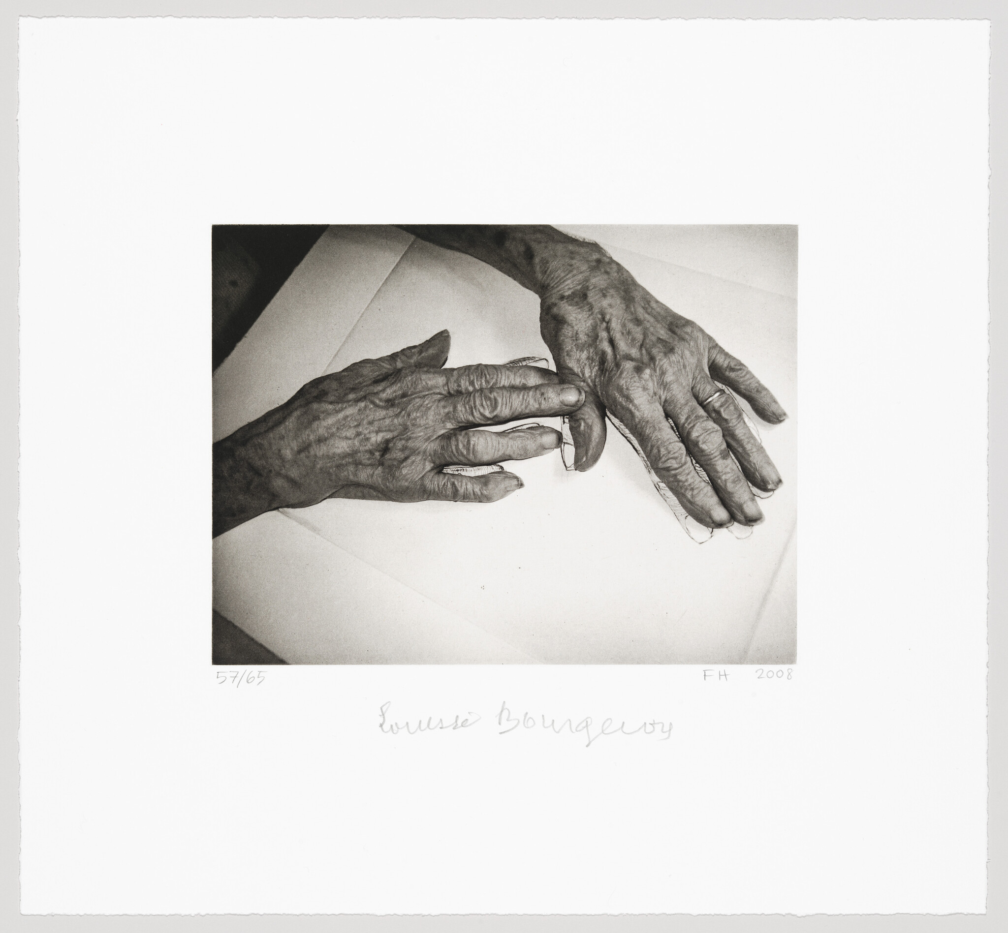 Two wrinkled hands rest on paper, one hand wearing a wedding ring.