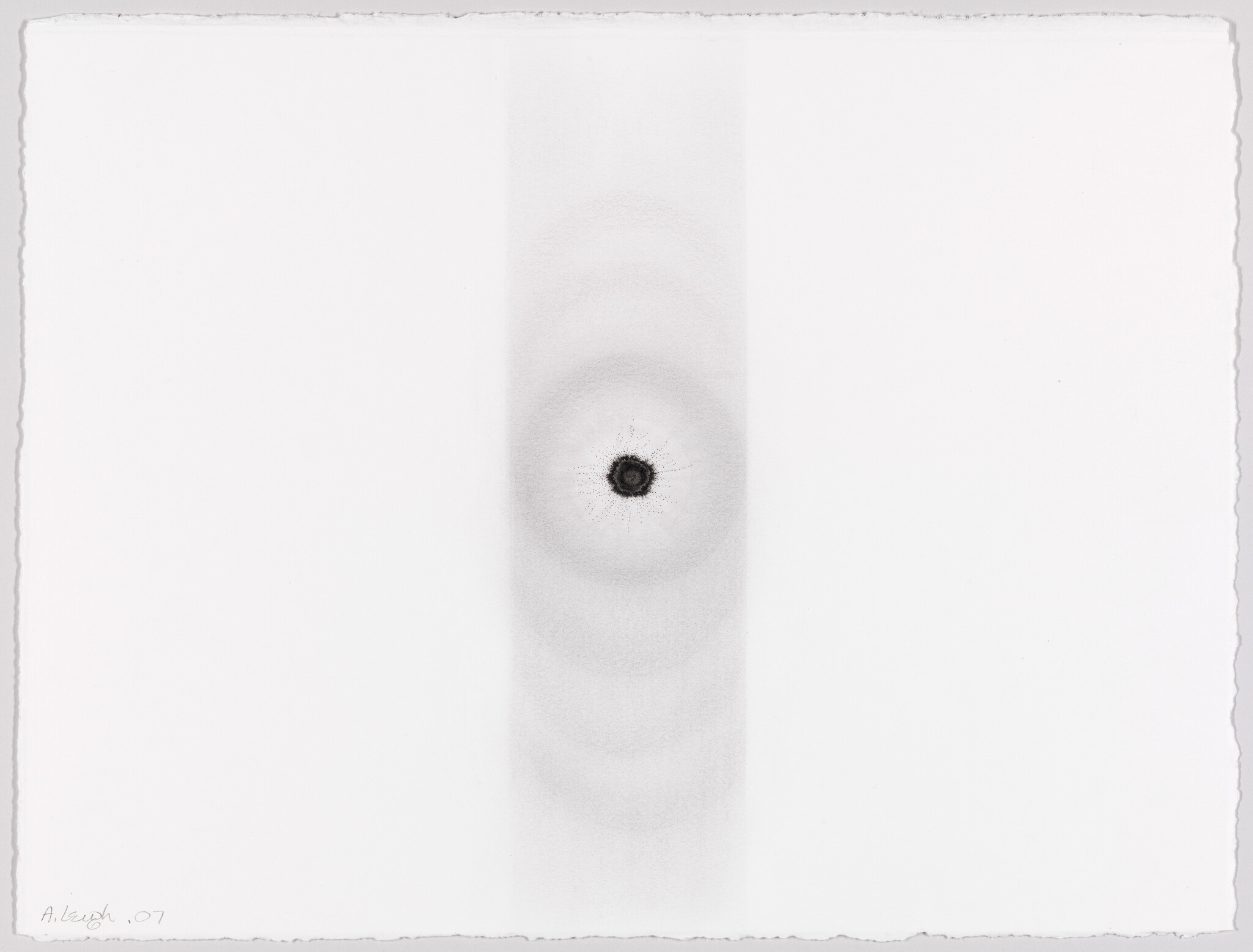 Small dark circular mark with faint concentric rings sits in a vertical pale band on white paper.