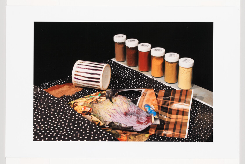 Spilled mug, scattered art supplies, and a row of spice jars on a polka-dot cloth.