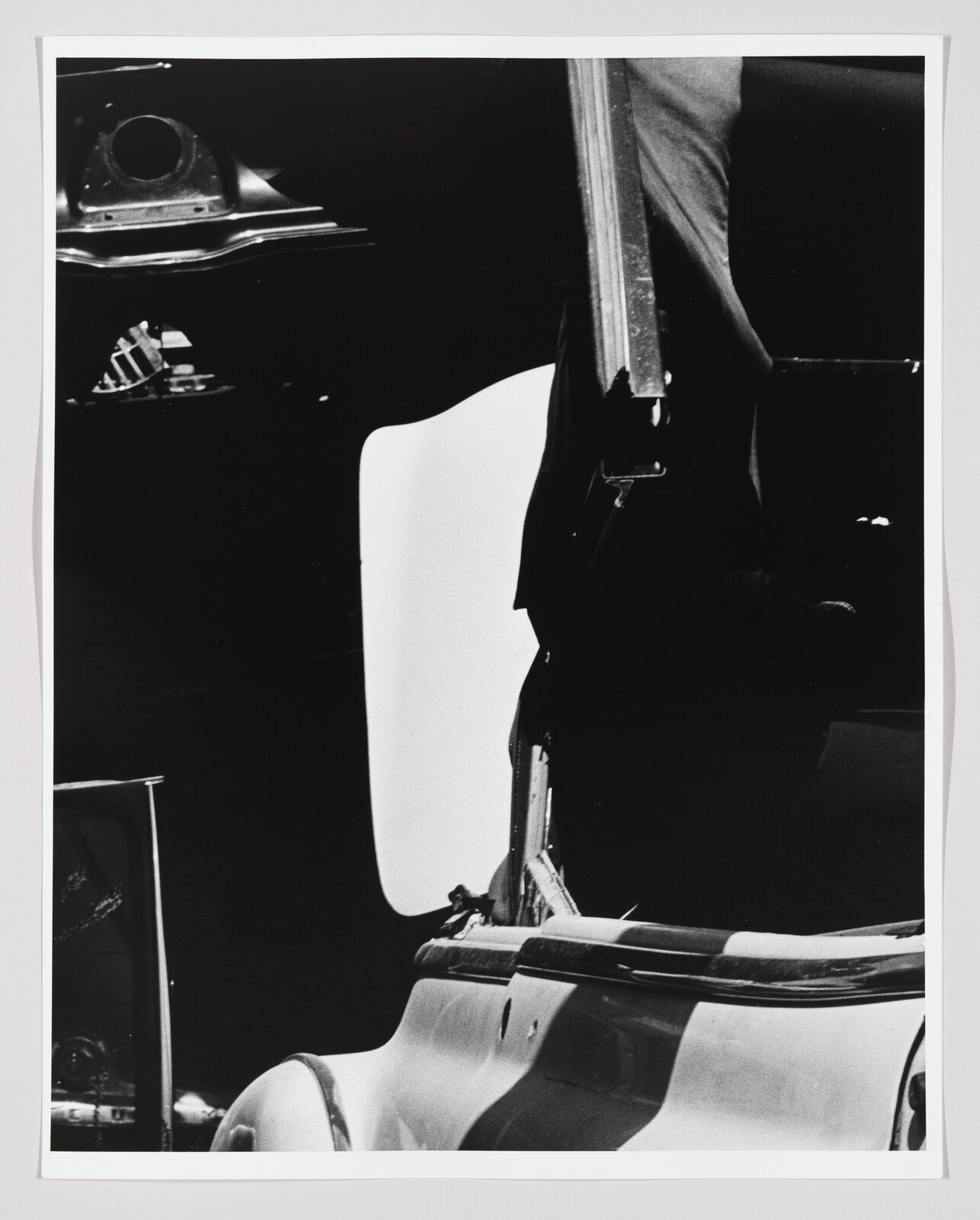 A black-and-white close-up of a car with its door open and convertible top raised.