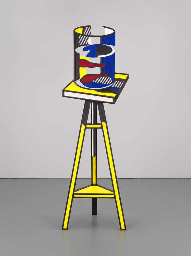 Tall yellow tripod stand holding a colorful cylindrical sculpture with blue, red, and black shapes.