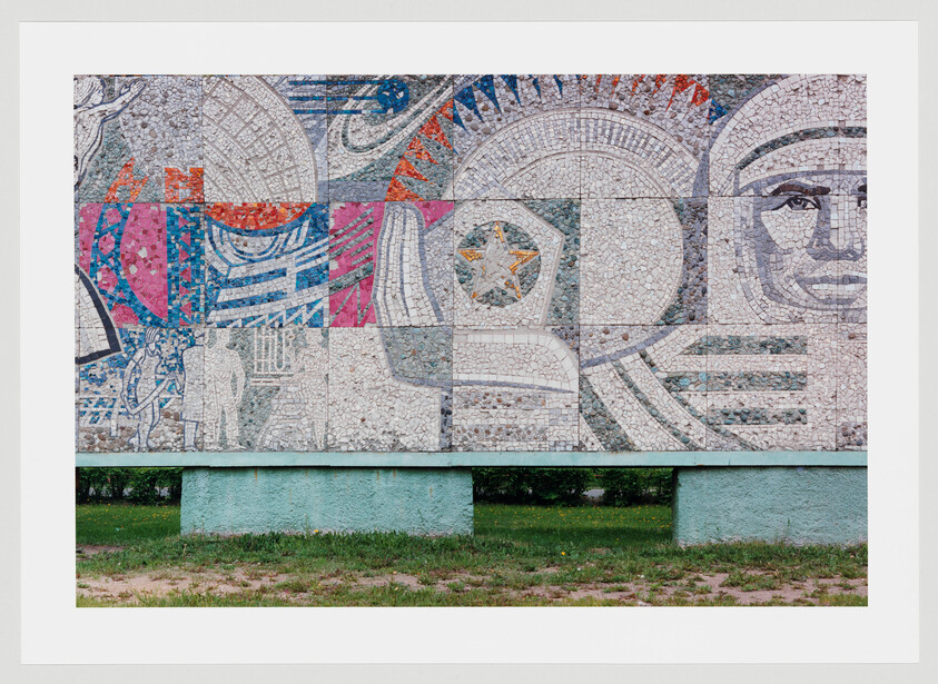 Large mosaic mural depicts a stylized astronaut face, star emblem, and abstract geometric patterns.