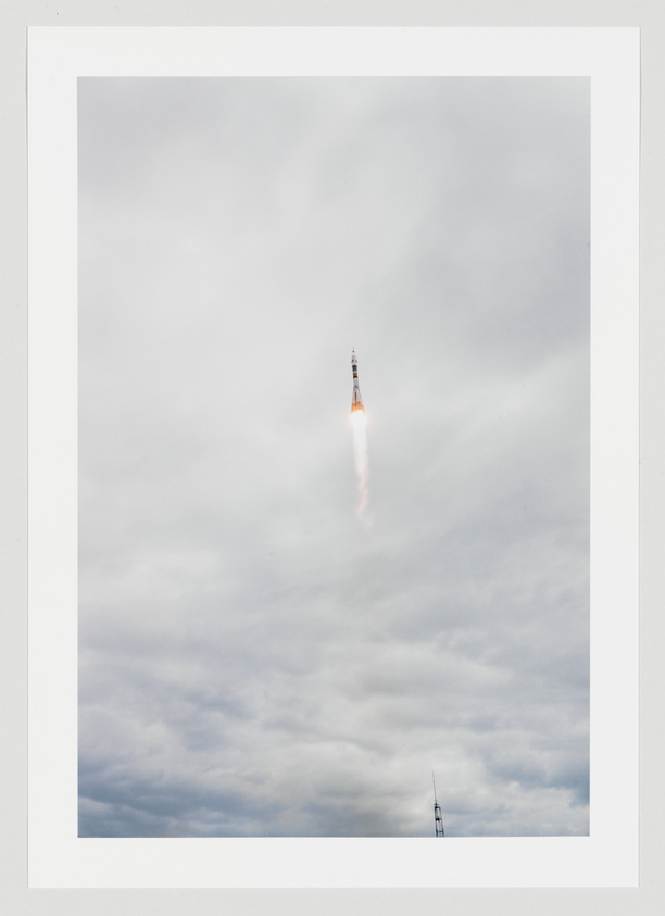 A rocket mid-launch with a fiery trail behind it, ascending into a cloudy sky.