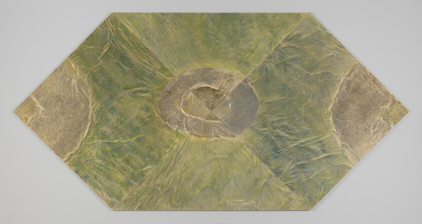 Aerial view of a circular volcanic crater with surrounding ridges on a hexagonal panel.