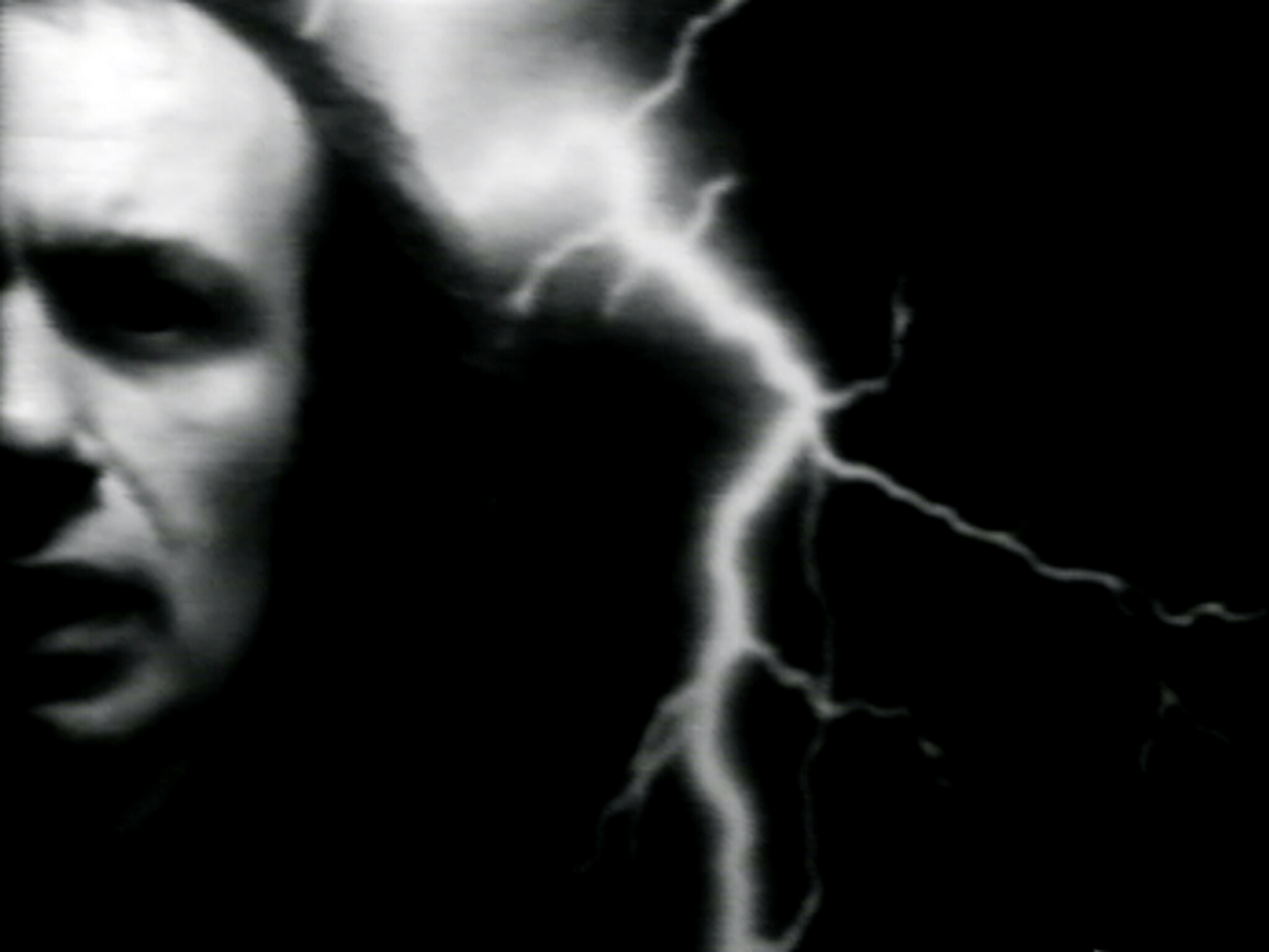 A partially visible person's face with a bright lightning bolt against a dark background.