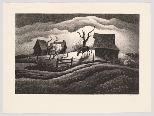 A lone horse grazes near a fence between two old barns under dramatic clouds.