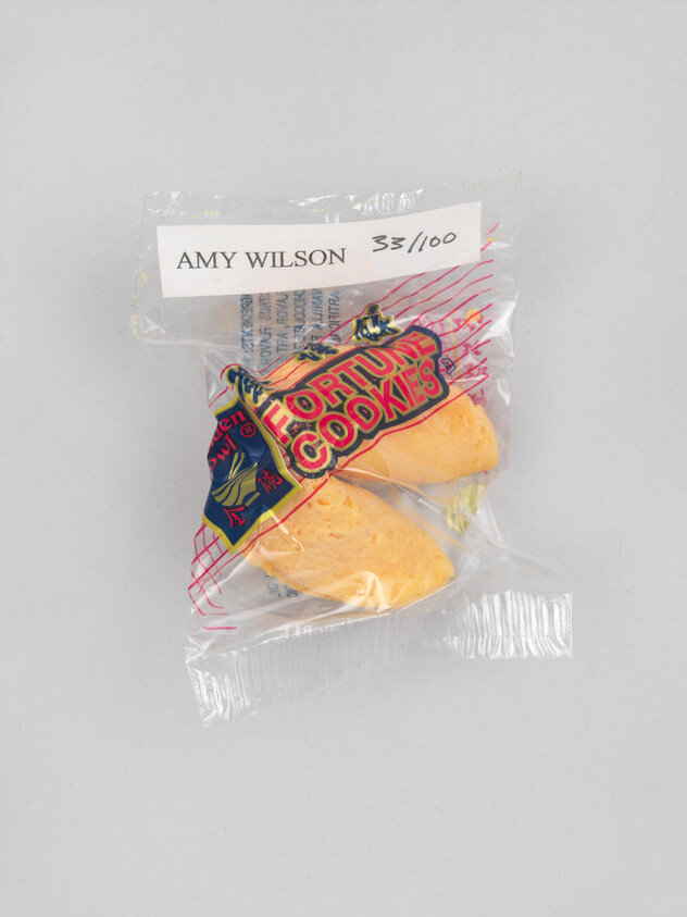 A packaged pair of fortune cookies in plastic wrap labeled Amy Wilson 33/100.