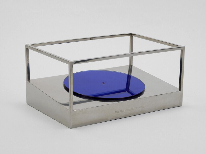 A reflective blue disk rests on the angled base of an open-sided steel cube&nbsp;